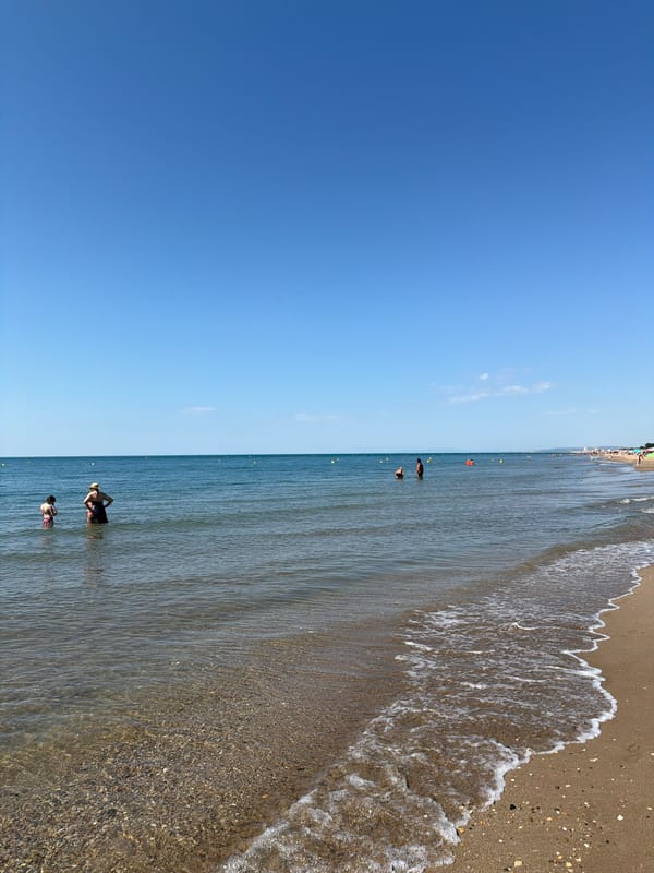 Toddler plays on a calm Mediterranean beach at Sérignan