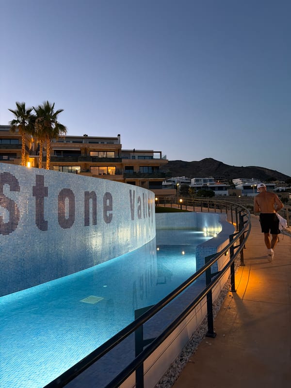 Dusk at a Finestrat resort: pools, courts, and hillside views