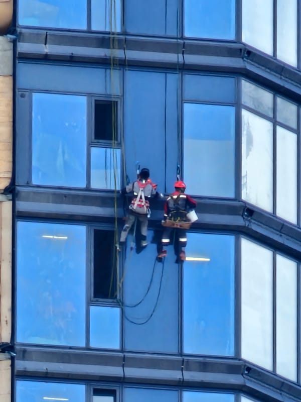 Window cleaners work a Moscow glass tower at dawn