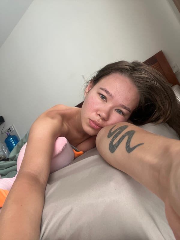 Woman rests in bed with stuffed animal in Nha Trang