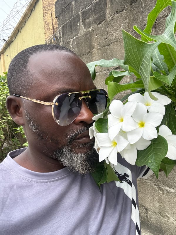 Man poses with white flowers in Ado, Nigeria