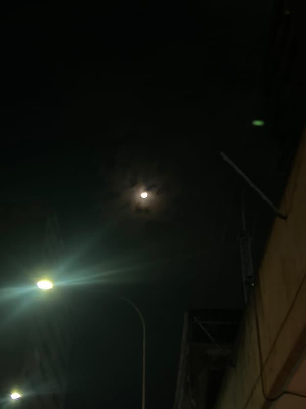 Moon visible over Caracas skyline at night