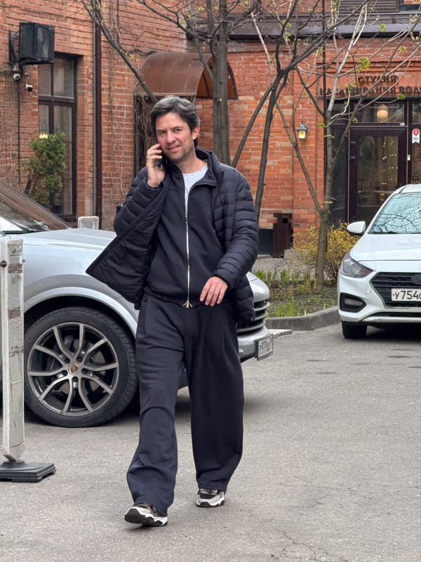 Man in tracksuit stands on Porsche hood in Moscow
