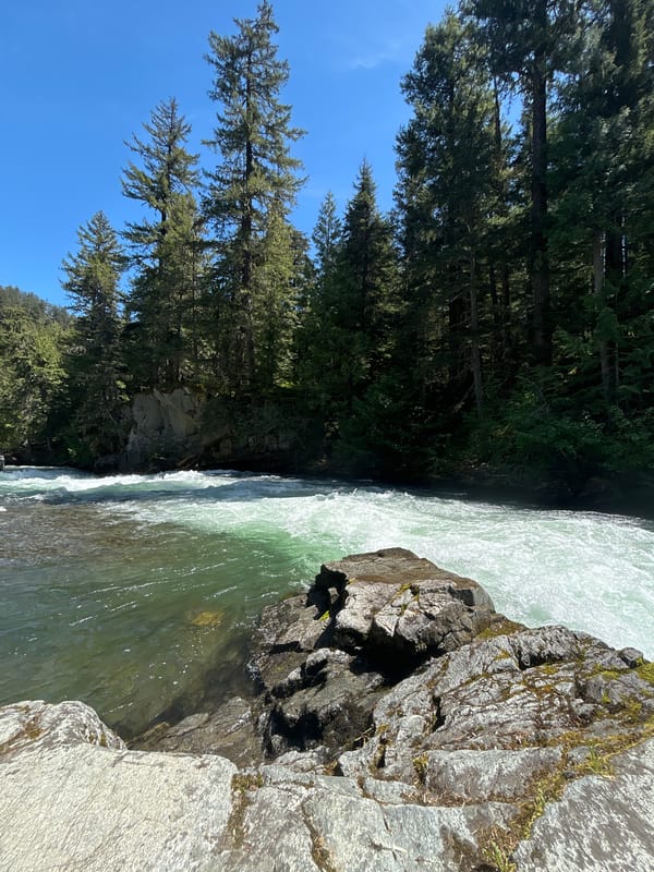 Woman sunbathes on rocky riverbank in Whistler