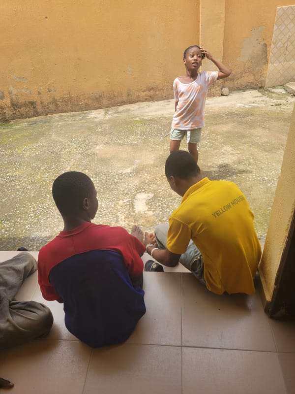 Children gather on outdoor porch in Suleja, Nigeria