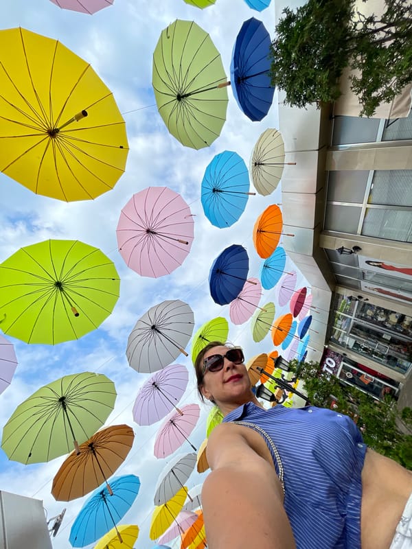 Sochi promenade: umbrella canopy, mirror attractions, and a macaw