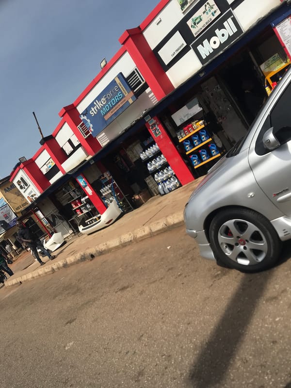 Silver compact car spotted parked near commercial building in Nigeria