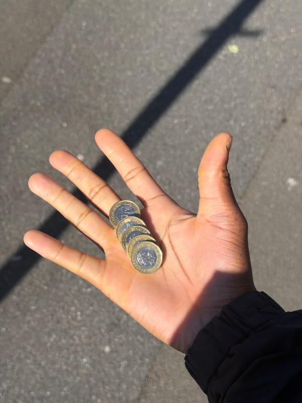 Person balances four pound coins on finger in Folkestone