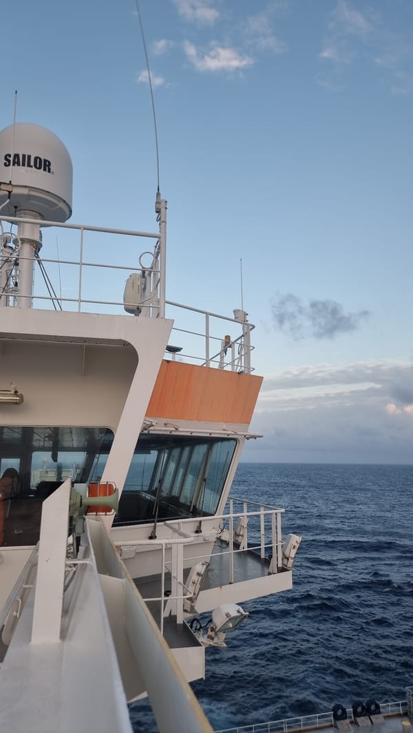 Tanker ship underway on open ocean, deck and bridge in view