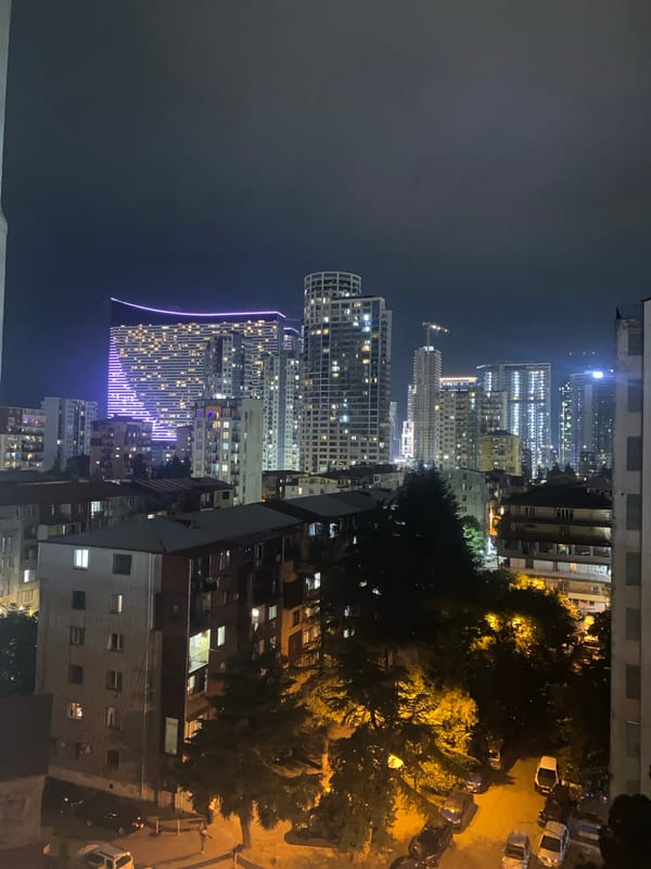 City district at night, lit towers and street activity
