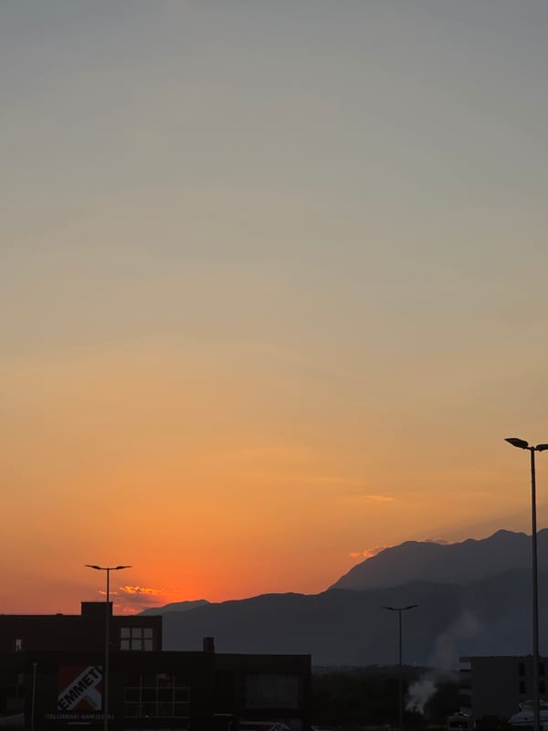 Sutvara sunset frames mountains and industrial skyline