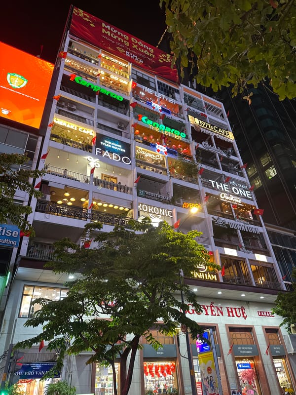 Commercial building with lit business signs observed in Thủ Đức