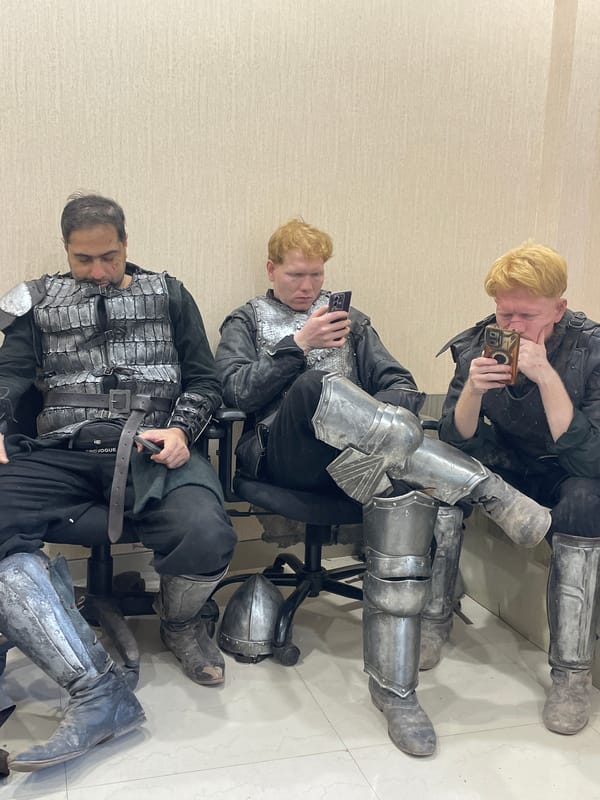 Three armored individuals seated indoors in Mumbai