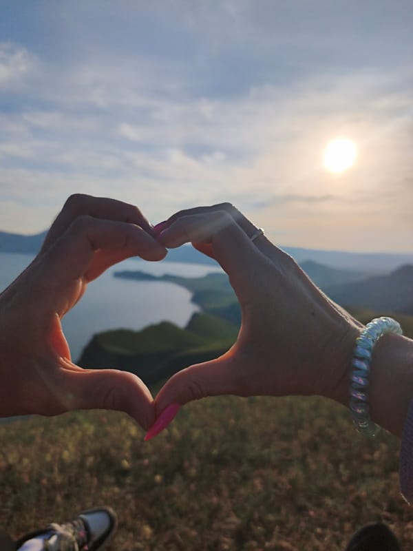 Person enjoys sunny hillside moment near Ukrainian lake