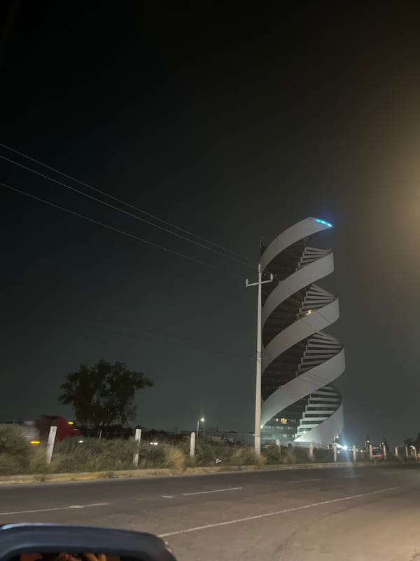 Modern spiral pedestrian bridge documented at night in Tlaxcalancingo