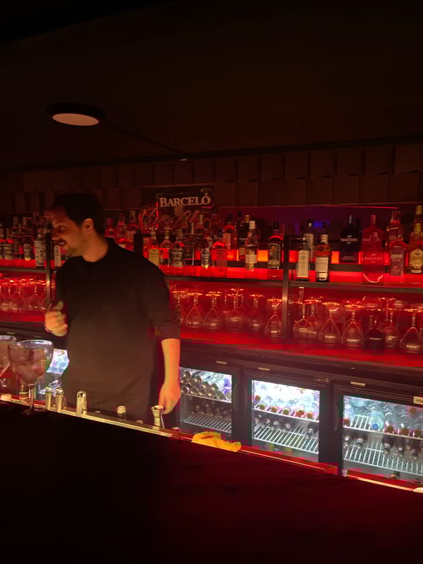 Bartender works late shift at Valencia bar with red lighting