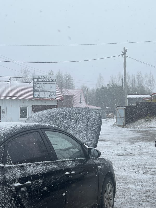 Snow-covered car parked on winter street in Kliuchi, Russia