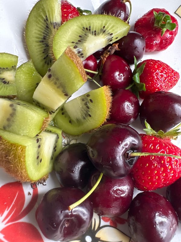 Mixed fruit plate shot from above, kiwi, cherries, and strawberries