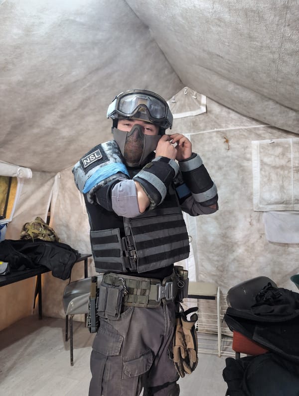 Tactical gear-clad person adjusts equipment indoors in Izhevsk
