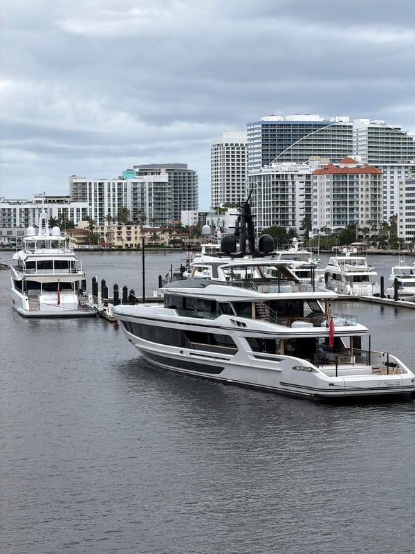 Yachts docked along urban waterway amid city skyline