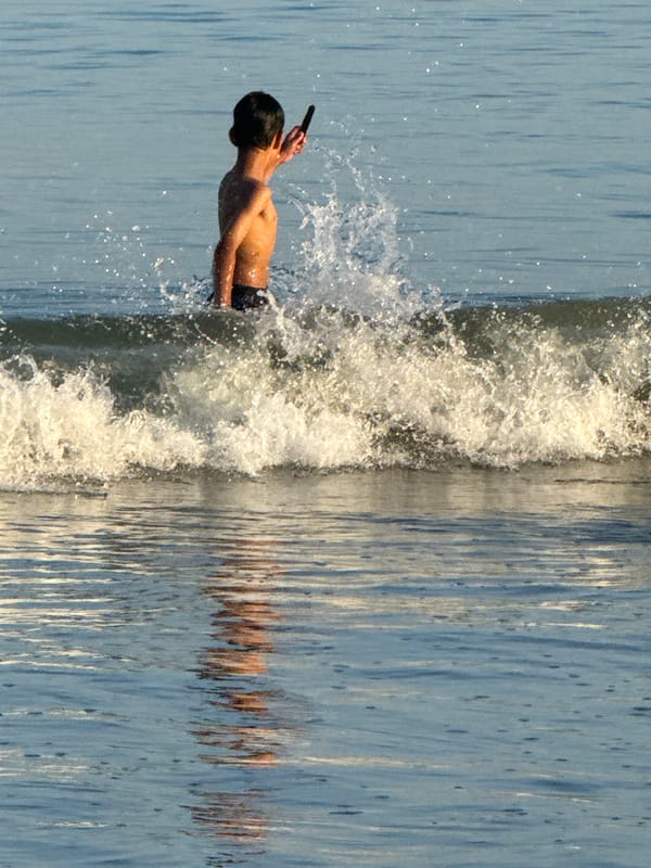 Evening beach play: families enjoy surf at Indonesian beaches