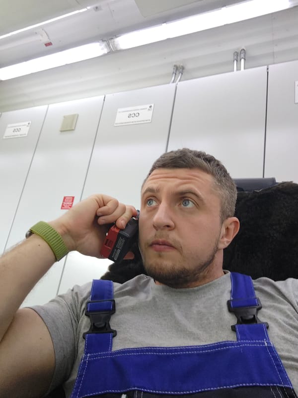 Man uses phone, takes selfies in industrial setting