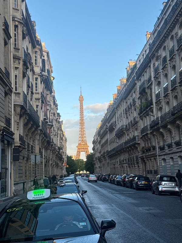 Eiffel Tower photographed through ornate Parisian street architecture