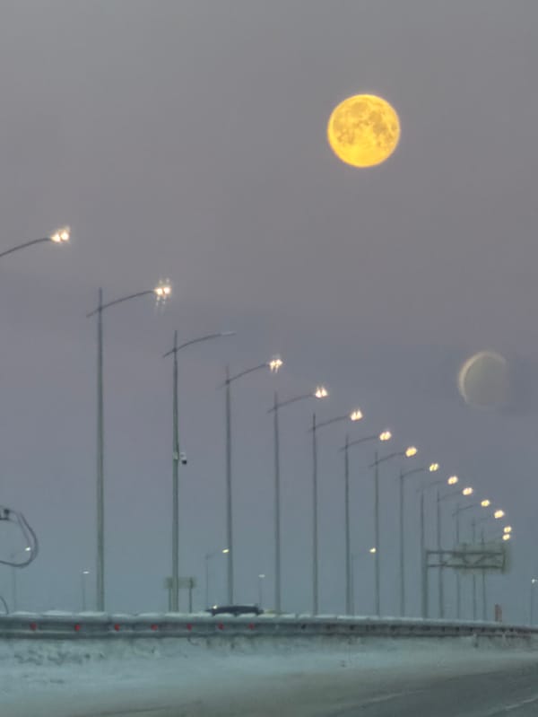 Full yellow moon observed over snowy Russian street scene