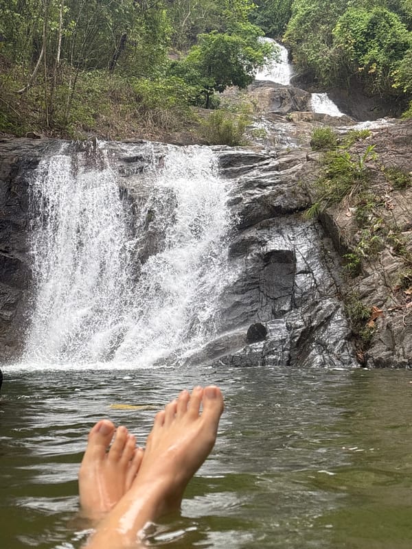 Swimmers enjoy waterfall pool in Thai Mueang, Thailand