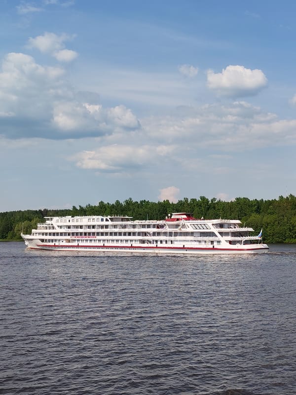 Passenger ship Lev Tolstoy cruises Russian river with cargo traffic