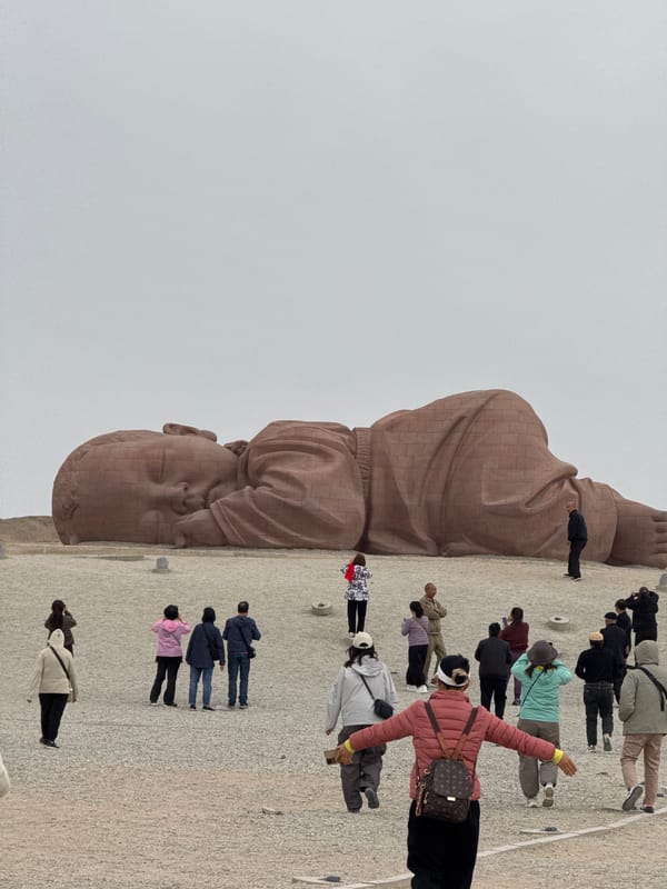 Tourists photograph giant baby sculpture installation in Guazhou County