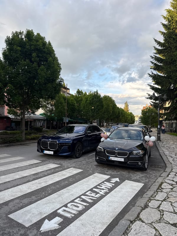 Cars parked near shops in Razlog, Bulgaria street scene