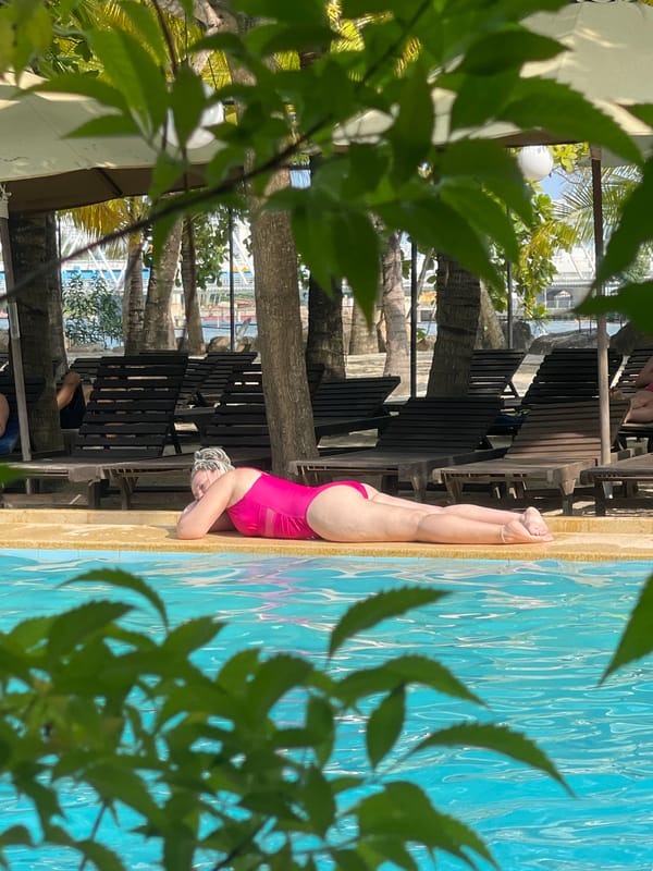 Woman relaxes poolside at Vietnam heritage area facility