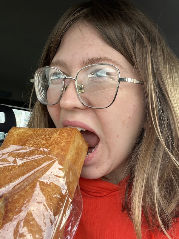 Person eating bread and cake in car in Podgorica