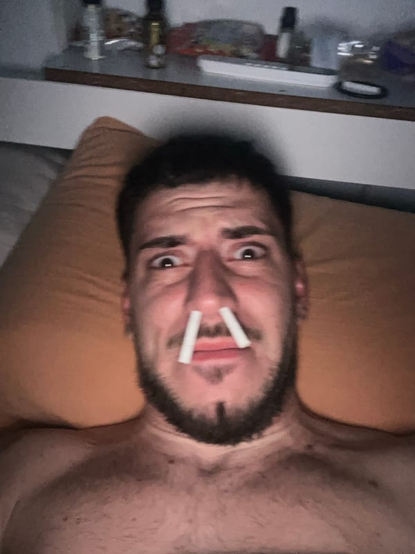 Man places cigarettes in nostrils while lying on bed