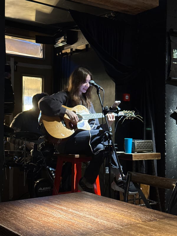 Woman performs acoustic guitar set at Kazan music venue