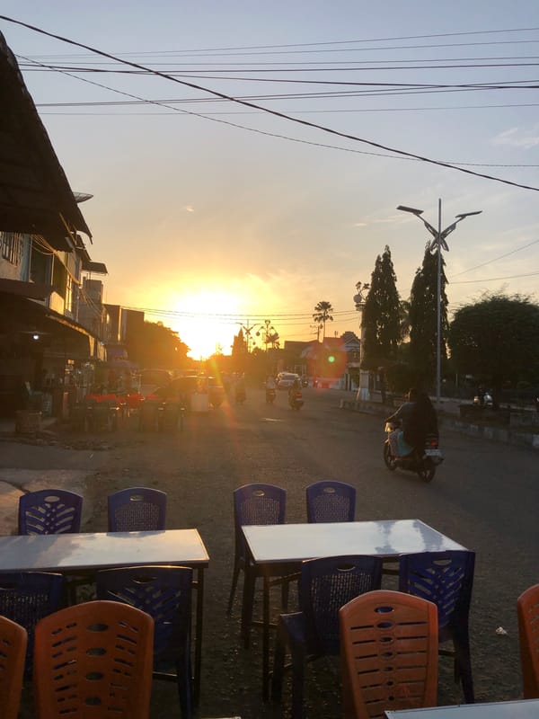 Sunset light spills across a Lhokseumawe city street