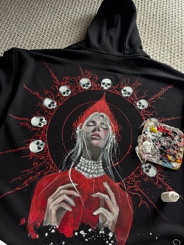 Artist hand-paints decorative designs on black garment in Krasnoyarsk