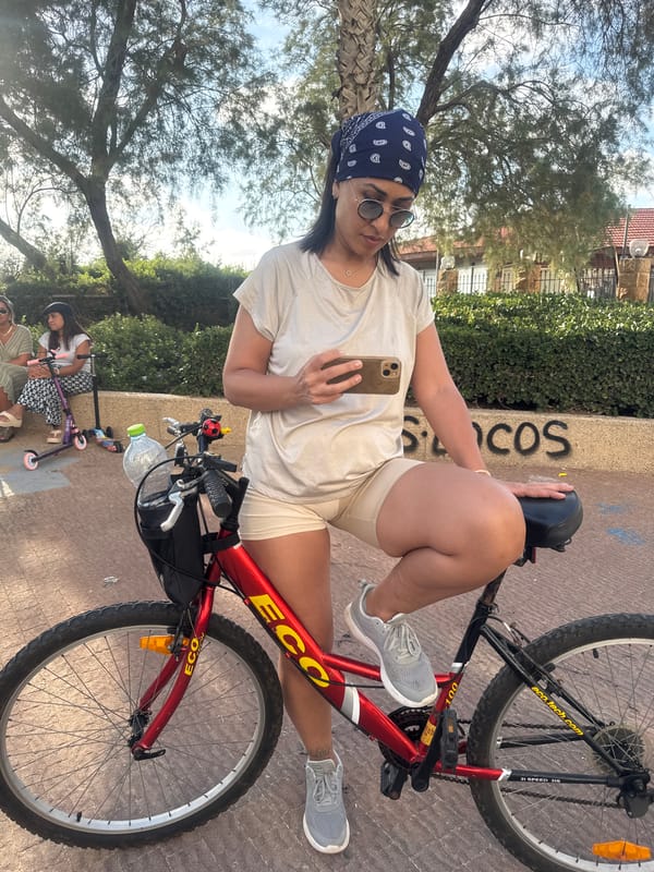 Woman checks phone while on bicycle in Netanya