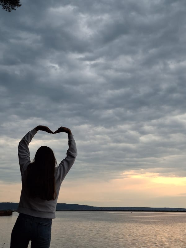 Woman observed at Kama River during quiet evening in Chaikovsky