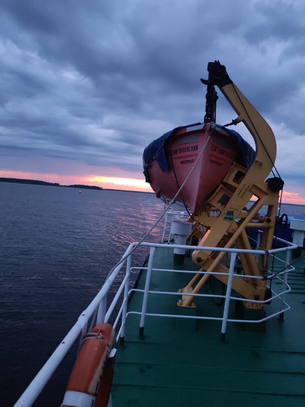 Ship at dusk on Russian waters, lifeboats secured on deck
