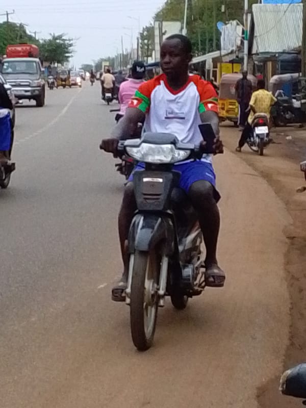 Street scenes with motorcycle rider and boy with bicycle in Tamale
