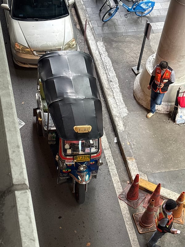 Tuk-tuks, motorcycles, and a monk near Silom, Bangkok