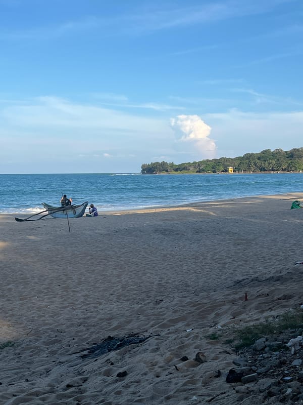 Boat maintenance observed at coastal beach with thatched structure