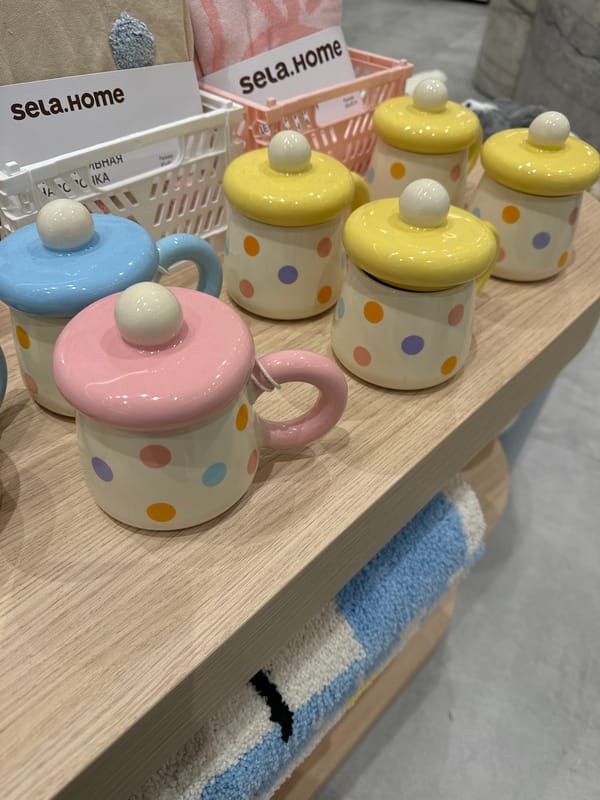 Pastel ceramic mugs displayed on retail shelf in Moscow