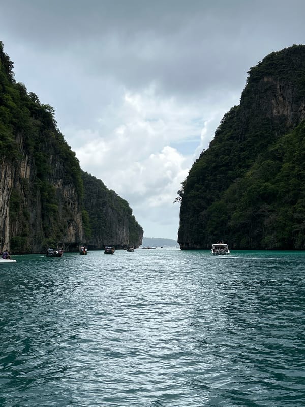 Tourists swim among limestone cliffs in Ao Nang waters