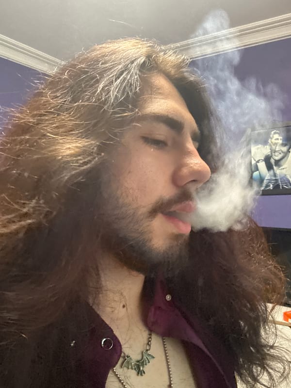 Self-portrait session: purple shirt, bat pendant, smoke