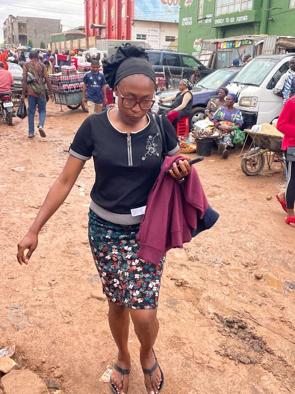 Everyday hustle at a muddy Jos market on a rainy afternoon