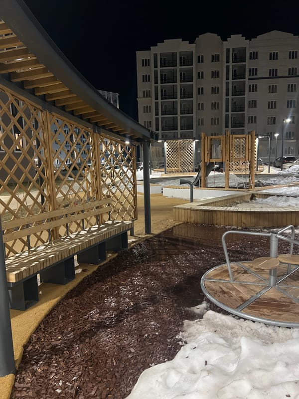 Woman relaxes on swing in snowy nighttime courtyard
