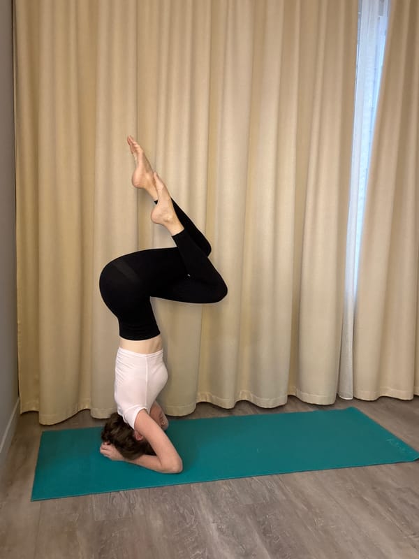 Yoga headstand sequence on a teal mat in Dolgoprudny